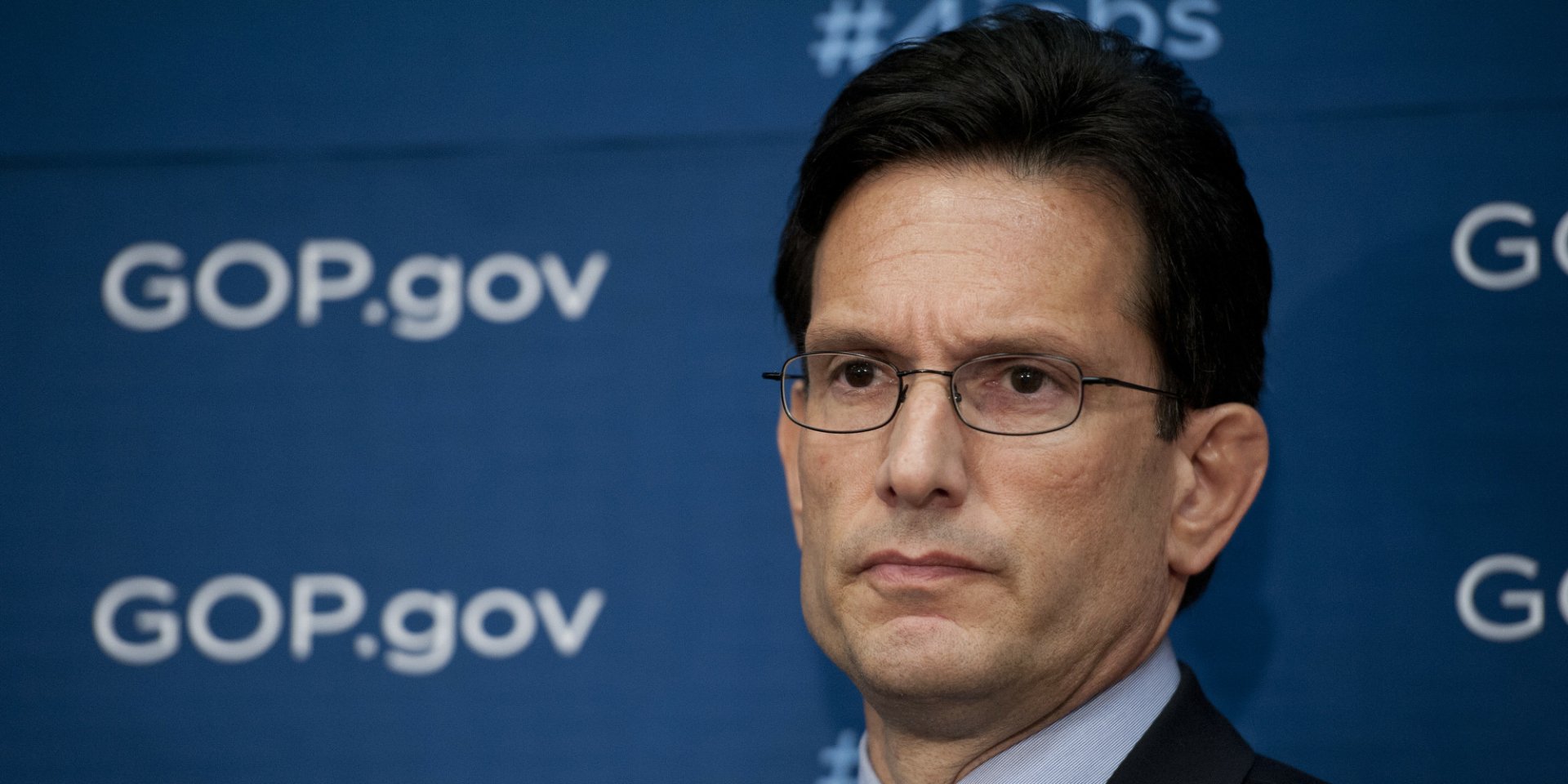 HD desktop wallpaper featuring a man in glasses with a serious expression, in front of a backdrop with the text #GOP.gov.