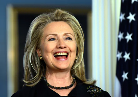HD wallpaper featuring a smiling woman with blonde hair in front of an American flag, serving as a desktop background.