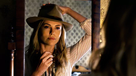 HD desktop wallpaper featuring Charlize Theron from the movie A Million Ways to Die in the West, wearing a hat and looking into a mirror.