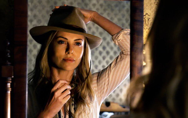 HD desktop wallpaper featuring Charlize Theron from the movie A Million Ways to Die in the West, wearing a hat and looking into a mirror.