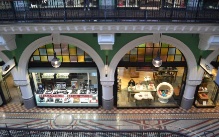 Interior view of the Queen Victoria Building in Sydney, Australia, showcasing a photography store with displays under elegant arches and detailed tiled flooring.