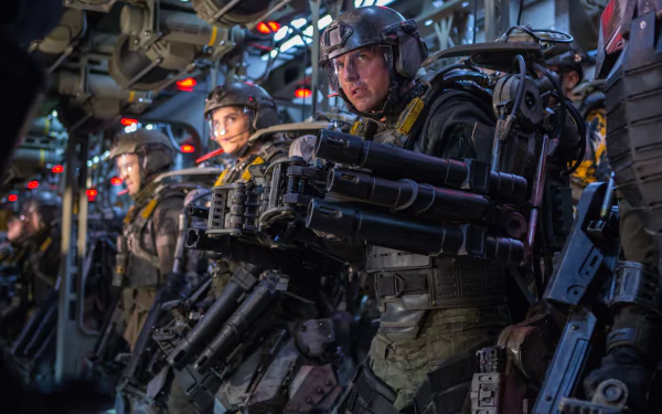 A scene from the movie Edge of Tomorrow, featuring Tom Cruise alongside fellow soldiers in futuristic gear, ready for battle in a high-stakes environment. 4K Ultra HD PC desktop wallpaper.