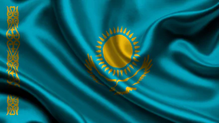 HD desktop wallpaper featuring the flag of Kazakhstan with its sun, eagle, and national ornamental pattern on a vibrant blue background.