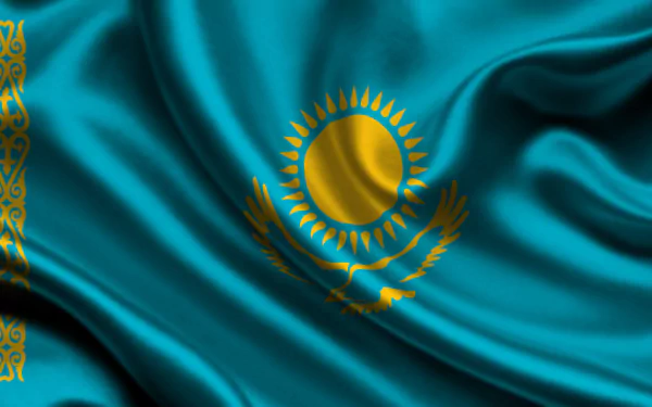 HD desktop wallpaper featuring the flag of Kazakhstan with its sun, eagle, and national ornamental pattern on a vibrant blue background.