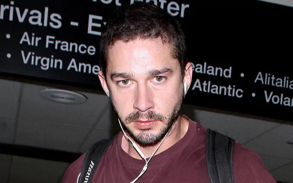 Shia LaBeouf captured in a candid moment at an airport, set as a high-definition desktop wallpaper.