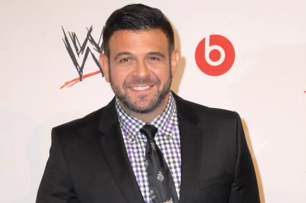 HD desktop wallpaper and background featuring a man in a suit with a checkered shirt, smiling at an event.