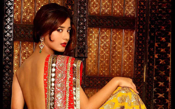 Amrita Rao poses elegantly in a richly adorned saree, showcasing traditional Indian attire against a beautifully intricate background in this striking HD wallpaper.