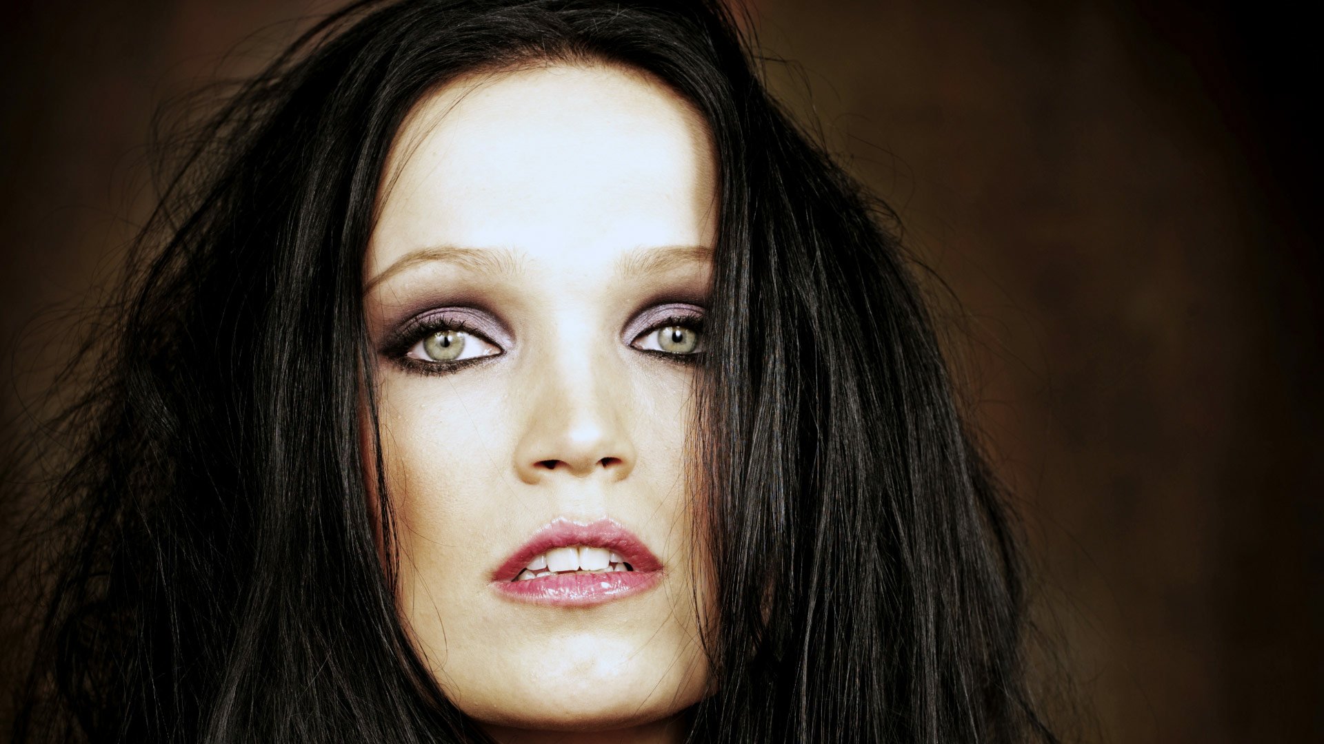 HD PC desktop wallpaper featuring a close-up of a woman with dark hair and intense eyes, representing the music band Nightwish.