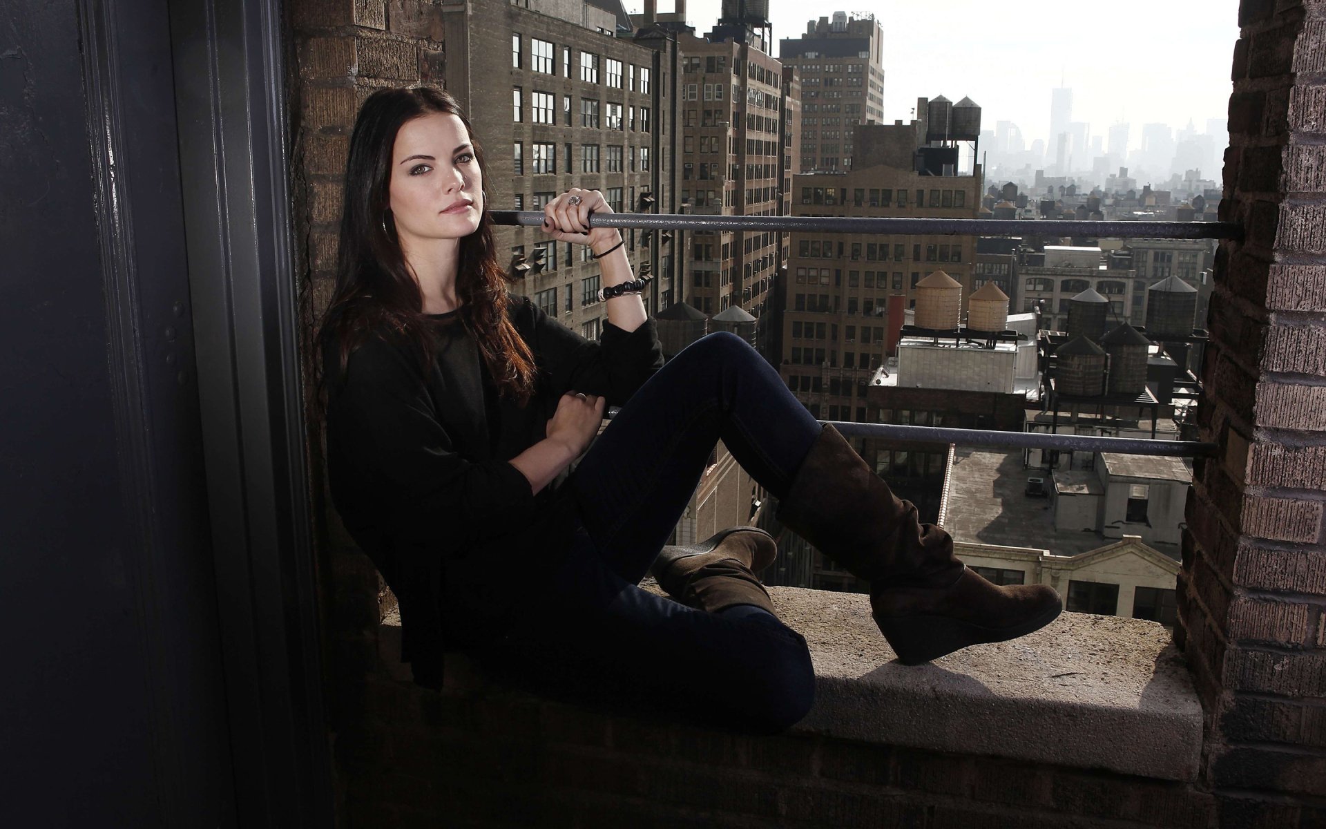 HD desktop wallpaper featuring American actress and celebrity Jaimie Alexander posing confidently in a cityscape setting.