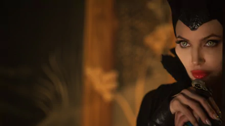 HD desktop wallpaper of Angelina Jolie as Maleficent, featuring a close-up with her wearing a horned headpiece and a mysterious expression.