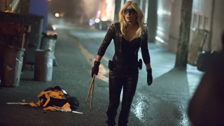 HD desktop wallpaper featuring Caity Lotz as Black Canary from the TV show Arrow, standing in a dimly lit urban alley with her signature combat outfit.