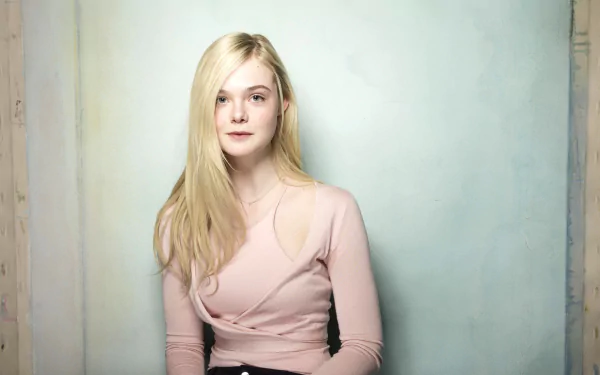 A high-definition wallpaper featuring American actress Elle Fanning, elegantly posed against a soft, muted background, showcasing her natural beauty and poise.