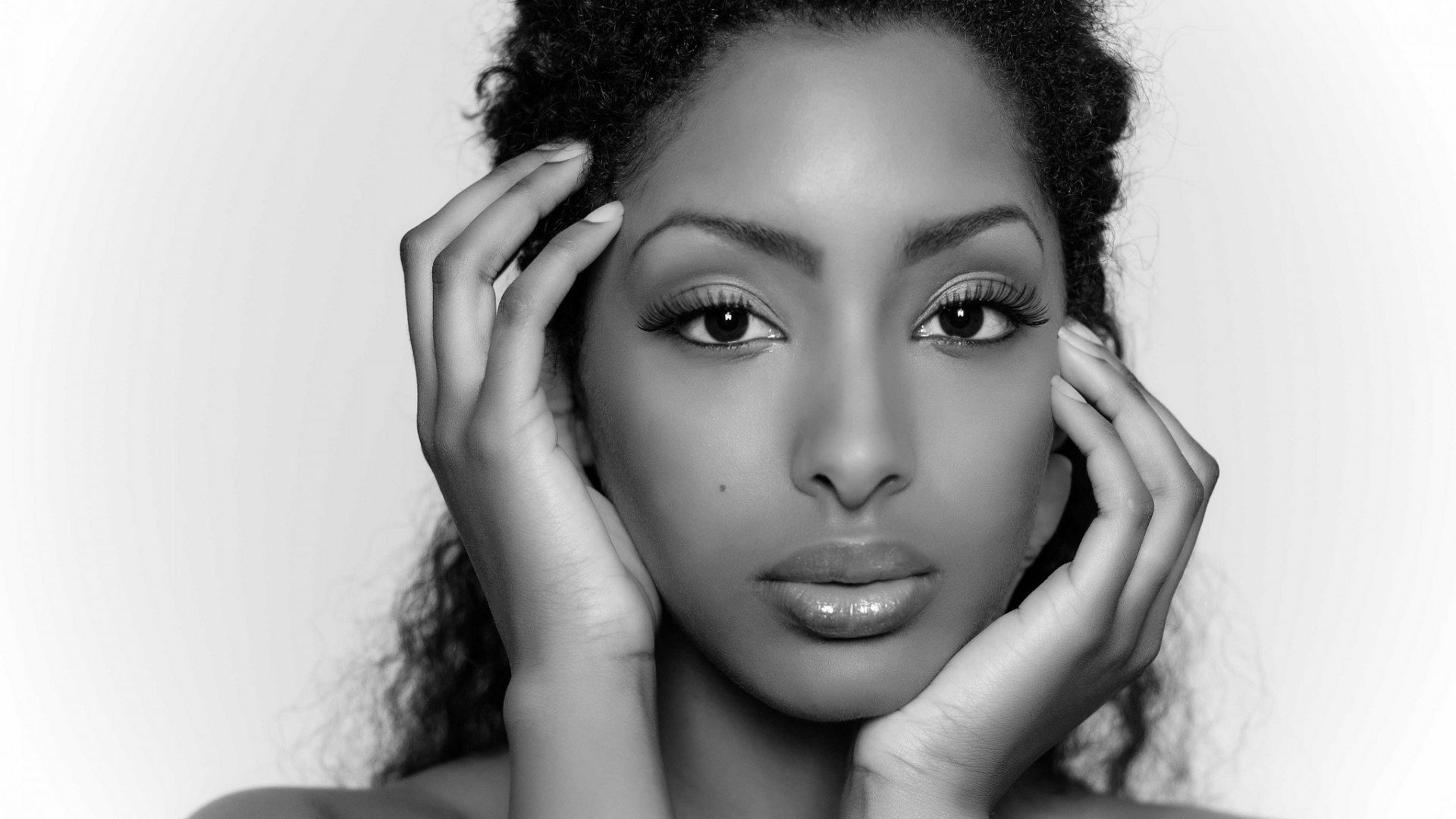 HD PC desktop wallpaper featuring a close-up black and white portrait of a woman with hands gently framing her face.