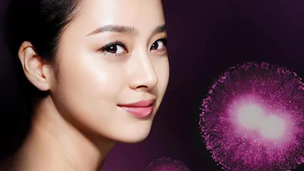 HD desktop wallpaper: close-up of a smiling Korean actress and celebrity with soft makeup and dark hair against a purple background dotted with glowing pink bokeh.