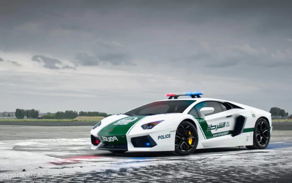 A striking Lamborghini Aventador police vehicle stands on a wet runway, showcasing its sleek design and vibrant colors, making for a captivating HD desktop wallpaper and background.