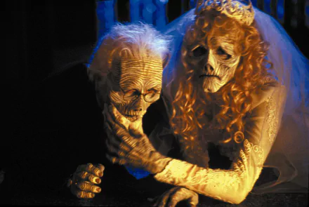 Beetlejuice movie scene: decayed skeletal bride and groom in wedding attire under blue light — 2K Quad HD PC desktop wallpaper/background.