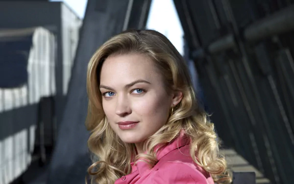 A stunning HD wallpaper featuring actress Sophia Myles, showcasing her elegant look with wavy blonde hair and a confident expression against a modern backdrop.