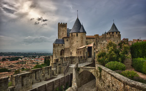 HD desktop wallpaper featuring the historic man-made fortress of Carcassonne under a dramatic cloudy sky.