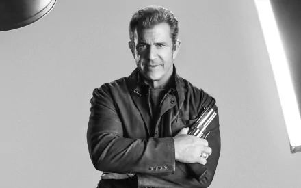 Black-and-white 2K Quad HD PC desktop wallpaper: stern middle-aged man in a jacket clutching throwing blades, cinematic portrait evoking Conrad Stonebanks from The Expendables 3.
