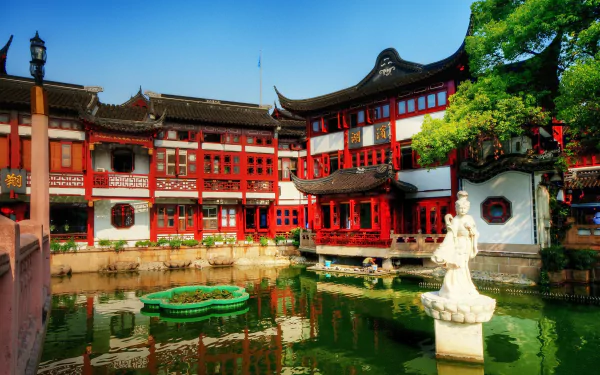 2K Quad HD PC wallpaper: Shanghai Tea Palace, a man-made red palace complex beside a reflective pond with stone statue and green trees under a clear blue sky.