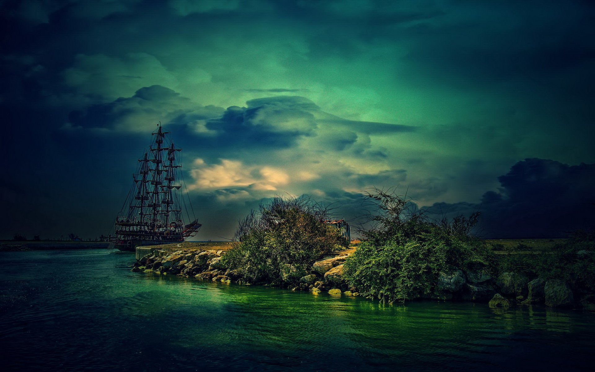 HD desktop wallpaper featuring a sailboat near a small, tree-covered island under a dramatic, cloudy sky over calm waters.