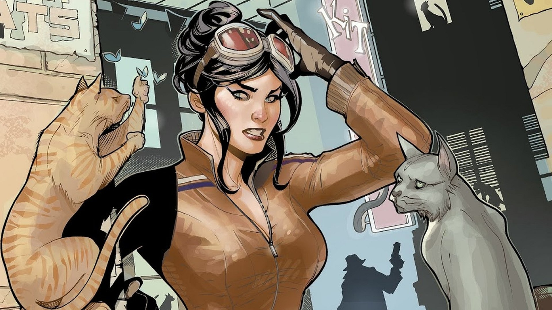 HD PC desktop wallpaper featuring a comic-style Catwoman in a brown suit, adjusting her goggles with two cats nearby in an urban setting.