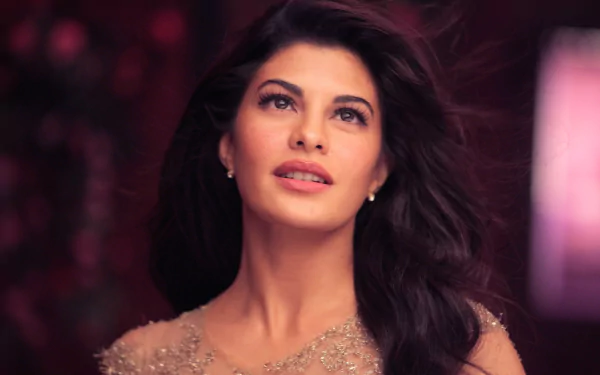 A stunning HD desktop wallpaper featuring Indian celebrity Jacqueline Fernandez, captured in an elegant pose with flowing hair and a soft, radiant expression.