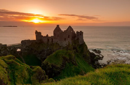 HD desktop wallpaper: Dunluce Castle ruin on Irish cliffs at sunset, man-made fortress overlooking the Atlantic.