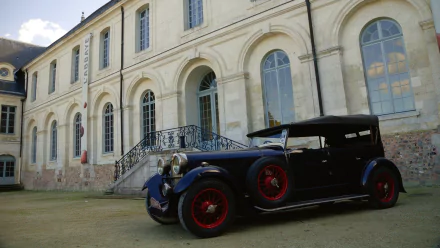 A classic Lagonda 16/80 vehicle parked in front of a historic building, captured in high definition for a PC desktop wallpaper and background.