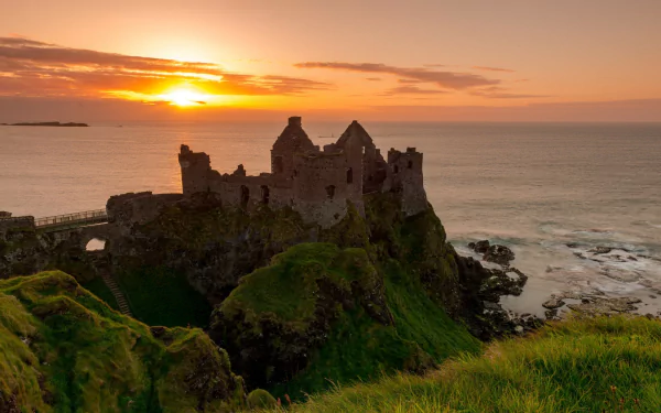 HD desktop wallpaper: Dunluce Castle ruin on Irish cliffs at sunset, man-made fortress overlooking the Atlantic.