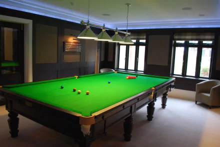 HD desktop wallpaper featuring a well-lit snooker and pool room with a green ball table under hanging lights in a modern, spacious man-made interior.