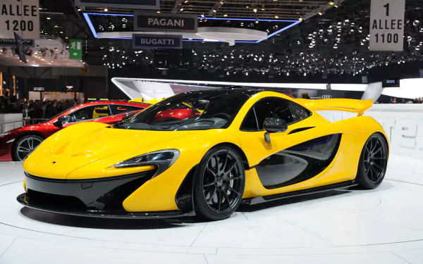 A striking McLaren P1 in vibrant yellow displayed at an auto show, showcasing its sleek design and aerodynamic features, making for an impressive HD desktop wallpaper.