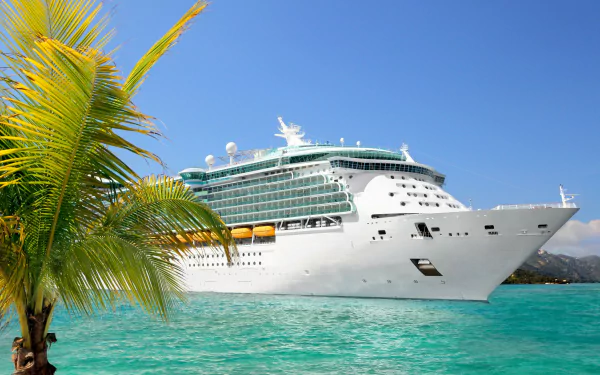 A large cruise ship anchored in vibrant turquoise water, framed by palm trees, creating a serene tropical scene. This HD image serves as a stunning desktop wallpaper.