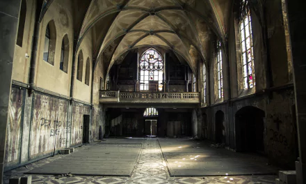Interior view of an abandoned, rusted urban ruin in Germany with gothic arches and stained glass windows, captured in 4K Ultra HD with HDR detail.