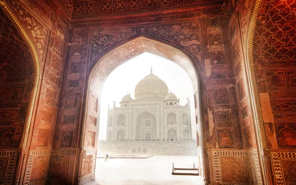 A stunning HD wallpaper featuring the majestic Taj Mahal framed by an ornate archway, showcasing intricate craftsmanship and architectural beauty.
