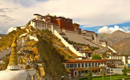 HD desktop wallpaper featuring the Potala Palace, a man-made architectural marvel in Tibet, China, set against a scenic mountainous backdrop under a cloudy sky.