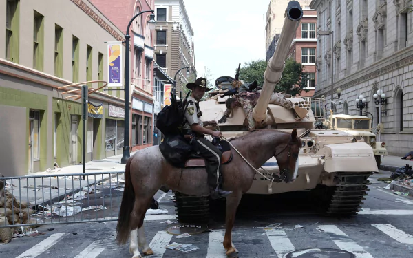 HD PC desktop wallpaper featuring Rick Grimes (Andrew Lincoln) from The Walking Dead, showing him on horseback in an urban street setting with a military tank.