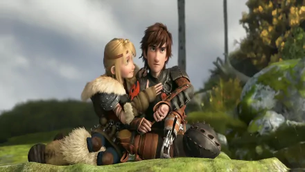 Astrid and Hiccup from How to Train Your Dragon 2 share a warm moment on a grassy hill, surrounded by a vibrant natural backdrop in this HD desktop wallpaper.