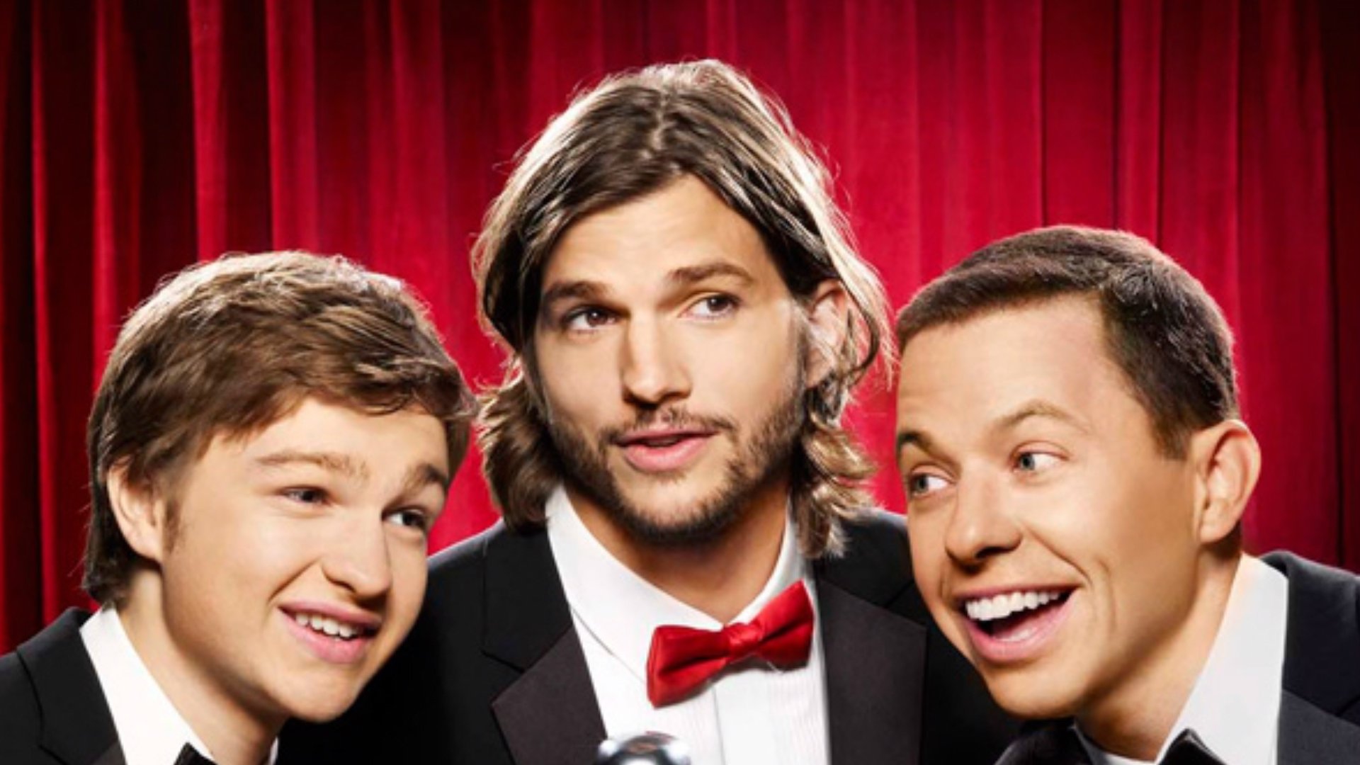 HD desktop wallpaper featuring the main cast of the TV show Two and a Half Men against a red curtain backdrop.