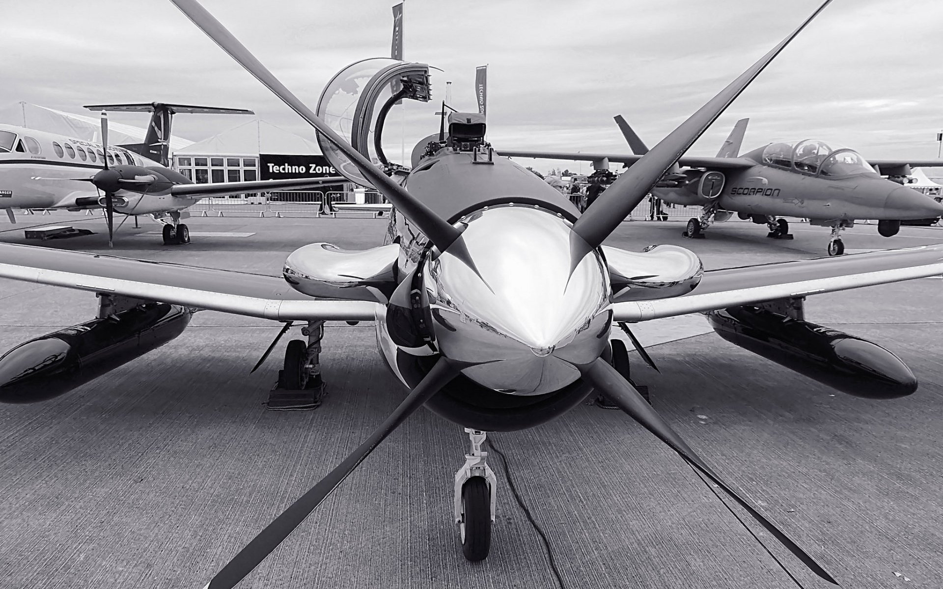 Front view of a Beechcraft T-6 Texan II military trainer on a tarmac with other aircraft; HD PC desktop wallpaper/background.