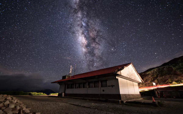 Sci‑Fi 4K Ultra HD PC desktop wallpaper: Milky Way arcing over an isolated coastal building, vivid galactic core and starfield bathing the night sky.