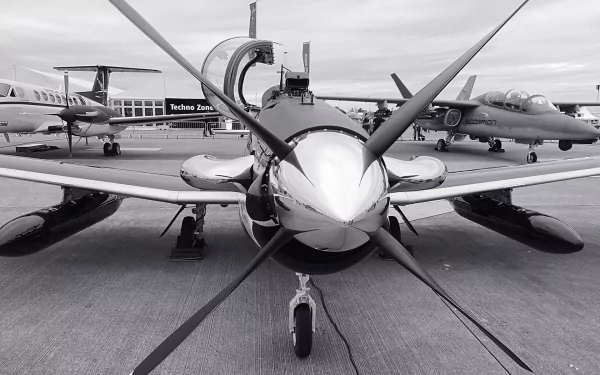 Front view of a Beechcraft T-6 Texan II military trainer on a tarmac with other aircraft; HD PC desktop wallpaper/background.