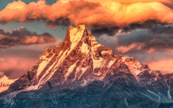 A stunning view of a Himalayan mountain peak bathed in warm sunset hues, showcasing the vibrant colors of nature in a high-definition wallpaper.