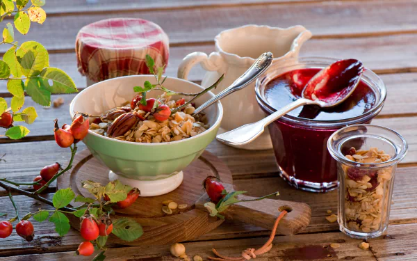 HD desktop wallpaper of a still life breakfast scene with muesli in a bowl, jars of jam, and rustic wooden table accents.