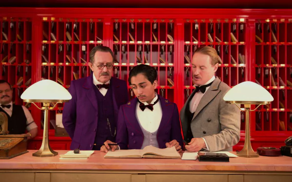 HD desktop wallpaper of the lobby scene from the movie The Grand Budapest Hotel, set in a vibrant red Budapest hotel interior.
