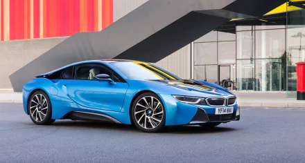 A sleek blue BMW i8 parked against a modern backdrop, showcasing its elegant design. This HD desktop wallpaper captures the vehicle's striking lines and vibrant colors.