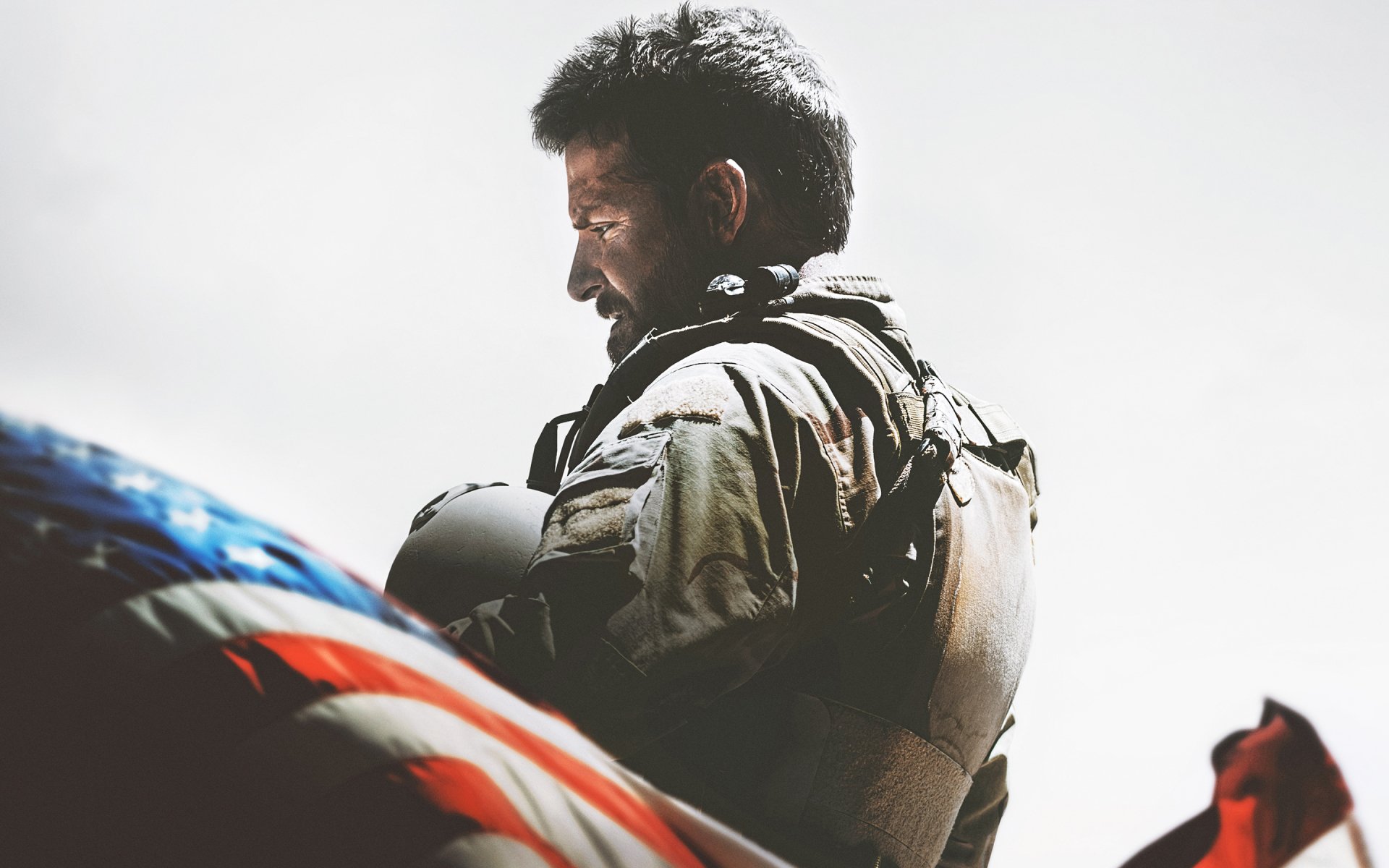 A dramatic HD desktop wallpaper from the movie American Sniper, featuring a soldier against a backdrop of the American flag, capturing themes of bravery and sacrifice.