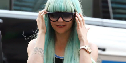 HD desktop wallpaper of a woman with teal hair and sunglasses, evoking a trendy, urban vibe.