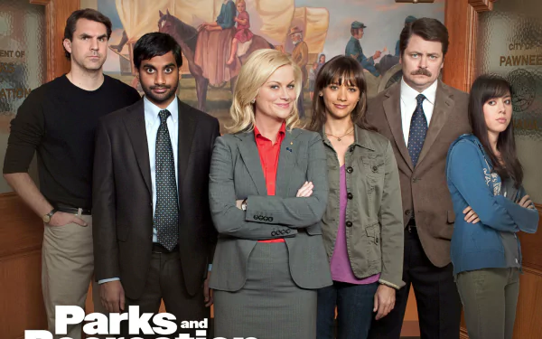 HD desktop wallpaper featuring cast members of Parks and Recreation with a show-themed backdrop.