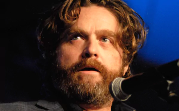 HD desktop wallpaper featuring a bearded man with a microphone in a blue-lit setting, providing a creative and engaging background.